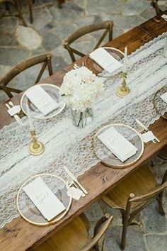 the table is set with place settings and flowers