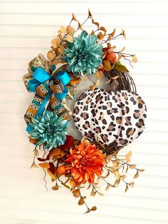 a wreath with leopard print and flowers on the front of it, hanging on a wall