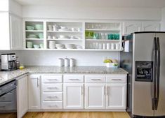 a kitchen with white cabinets and stainless steel appliances, including a silver refrigerator freezer