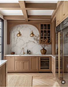 a large kitchen with marble counter tops and wooden cabinetry, along with gold accents