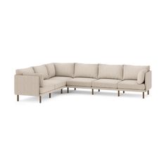 a large sectional couch sitting on top of a white floor next to a wooden frame