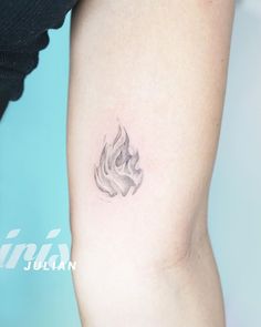 a woman's arm with a tattoo that has a fire symbol on the side