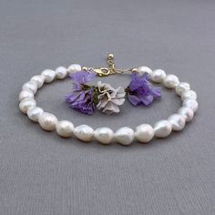 ✦This lightweight and easy to wear bracelet has a strand of white baroque shaped freshwater pearls strung on sturdy beading wire. The pearls have a slightly irregular shape and measure approximately 6mm x 7mm   ✦The bracelet closes with a sturdy lobster clasp and section of large link chain to allow for adjustment in length. Bracelet length is available in 4 lengths: Small 6 to 7", Medium 7 to 8", and Large 8 to 9", or custom length (up to 9").  ✦Comes in your choice of 14k gold filled or sterling silver components. ✦Your jewelry will be packaged in a beautiful and reusable organza bag. All items will be placed in the same organza bag. If you need a separate bag for each item, please leave a comment at check out. ✦Giving your purchase as a gift? If you would prefer that prices not be print Wedding Baroque Pearl Beaded Bracelets With Pearl Drop, Wedding Baroque Pearl Beaded Bracelet With Pearl Drop, Adjustable Pearl White Bracelet With Pearl Drop, Adjustable Dainty Baroque Pearl Bracelet, Dainty Adjustable Baroque Pearl Bracelet, Adjustable White Pearl Bracelet In 14k Gold Filled, Hypoallergenic White Pearl Bracelet In 14k Gold Filled, Adjustable Baroque Pearl Drop Bracelets, Single Strand Baroque Pearl Bracelet With Round Beads