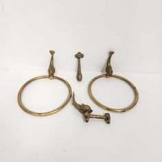 three antique brass towel rings with handles and knobs on each side, all in the same pattern