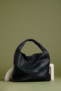 The black shoulder bag is a stylish, functional accessory. Crafted with vegan leather and a unique woven design, The Melie Bianco handbag offers a reliable choice for those seeing a timeless, fashionable look. The spacious interior of the shoulder bag is perfect for carrying all your essentials. Recycled Vegan Leather 15"W x 13"H x 5"D Handle Drop: 7.5" Magnetic Closure Removable Zip Pouch Unlined Fits up to an iPad Modern Woven Leather Hobo Bag For Daily Use, Modern Woven Hobo Bag With Double Handle, Black Woven Leather Crossbody Bucket Bag, Modern Woven Double Handle Hobo Bag, Intrecciato Weave Hobo Shoulder Bag For On-the-go, Trendy Travel Hobo Bag In Woven Leather, Trendy Woven Leather Hobo Bag For Travel, Trendy Intrecciato Hobo Bag For Travel, Trendy Intrecciato Weave Hobo Bag For Travel