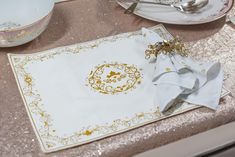 a place mat and napkin on a table with silverware in the backround