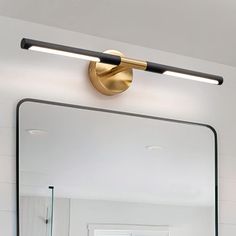 a bathroom with a mirror and lights on the wall