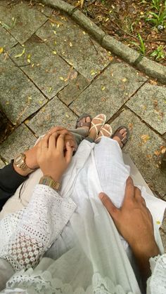 a person sitting on the ground with their feet up next to a woman's hand