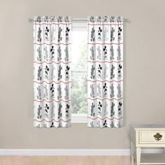 a window curtain with black and white cats on it in front of a gray wall