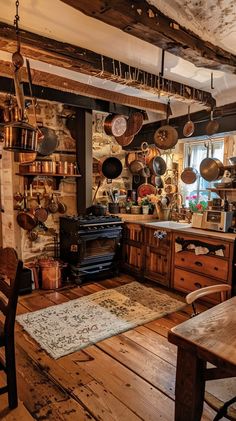 an old fashioned kitchen with pots and pans hanging from the ceiling