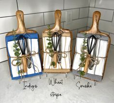 three kitchen utensils are wrapped in paper and tied with twine