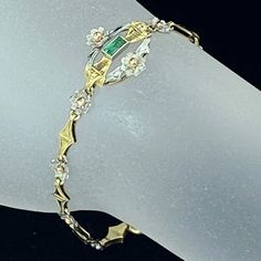 One Art Deco 18k Bi Color Gold Bracelet. Featuring A Straight Cut Emerald In The Center Of An Open Oval Ring, The Gem Is Approx 2.5 X 4.3mm, Weight 0.18ct, A Small White Gold Flower With A Yellow Bead Adorns On Both Side. The White Flower Punctuated With A Folding Rhombus Shape Link Is Bracelet Chain, Large Spring Ring Clasp. The Center Ring Is 17.5 X 15.3mm. The White Flower Is 5.31mm. Bracelet Is 6.26" Long, Weight 5.4gm, Hallmark 18k (1 Inch = 25.4 Mm; 1 Dime = 17.9mm). All Jewelry Items Are Pre-Owned Unless Otherwise Stated. This Means They Have The Usual Aspects Of Pre-Owned Jewelry, Such As Light Scratches, Wear And Tarnish. Please Review All The Photos Which Will Be Part Of The Descr Elegant Gold Diamond Bracelet With Emerald Cut, Yellow Gold Bracelet With Baguette Diamonds, Formal Yellow Gold Bracelet With Baguette Diamonds, Rhombus Shape, Oval Rings, First Art, Gold Flowers, Yellow White, Spring Rings