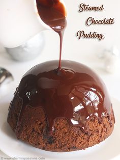 a chocolate pudding is being drizzled with caramel sauce on a white plate