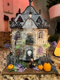 a doll house with pumpkins on the counter