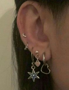 a close up of a person's ear with earrings on top of their ears