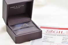 an engagement ring sits in a gift box next to a pass for $ 5, 500