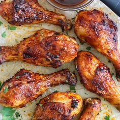 grilled chicken wings on parchment paper with dipping sauce in the bowl and parsley