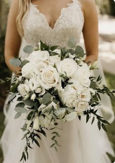 a bride holding a bouquet of white flowers