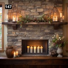 a stone fireplace with candles lit in front of it