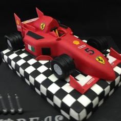 a birthday cake made to look like a race car on top of a checkered table