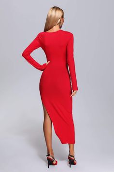 a woman wearing a red dress with long sleeves and high slits on the side