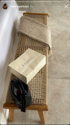 a bag sitting on top of a wicker bench next to a white bath tub