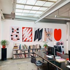 an office with lots of books on the wall and desks in front of it