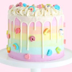 a rainbow cake with white frosting and sprinkles