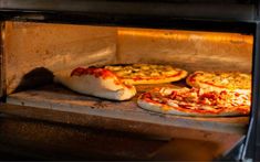 two pizzas are cooking in an oven