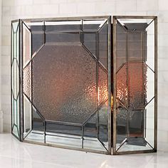 a glass fire place sitting on top of a white floor next to a wall mounted heater