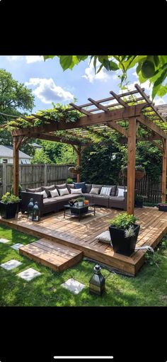 an outdoor living area with couches, tables and chairs in the grass next to a wooden deck