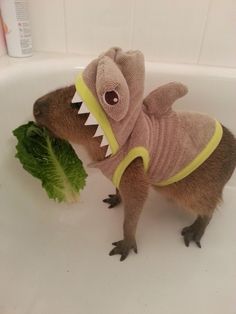 a stuffed animal in a bathtub with a green leaf