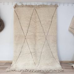 a white rug with fringes hanging on the wall