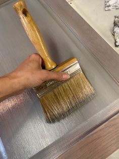 a person holding a brush on top of a metal surface