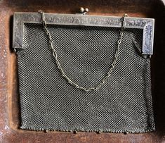 "This is an excellent evening bag - if you don't' wish to conceal anything in it. It is lovely. The bag is comprised of a chain mail mesh in German silver which descends from a stamped frame of German silver with a silvered brass clasp and chain. It is marked on its handle with an eye pictogram and the words German silver. The eye indicates that is was made by JT Inman, a silver company founded in Attleboro MA in 1882. The bag is pretty large for its type. It is 10\" wide X 9\" long. The chain i Silver Metal Chain Link Bag, Silver Rectangular Evening Bag With Chain Strap, Silver Evening Bag With Chain, Formal Silver Bag With Chain, Elegant Silver Chain Link Bag, Elegant Silver Bag With Chainmail Detail, Silver Evening Bag With Chain Detail, Silver Evening Bag With Chain For Everyday Use, Silver Metal Chainmail Bag