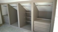 an empty walk in closet with drawers and shelves