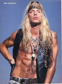 a man with long hair and no shirt on posing for a magazine cover, wearing an animal print bandana