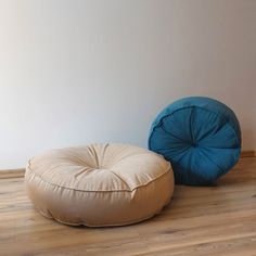 two bean bags sitting on the floor in front of a white wall and wooden floors