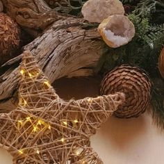 a wooden star and some pine cones are on the table with christmas lights in them