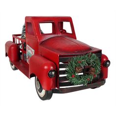 an old fashioned red truck with wreaths and pine cones on the front, isolated against a white background