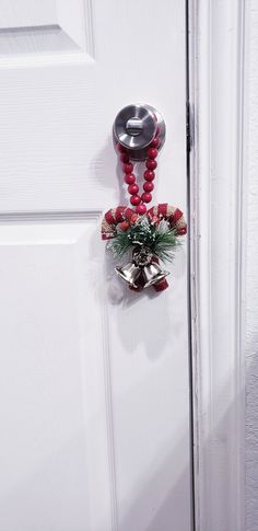 the door handle is decorated with red beads and holly wreaths, as well as bells