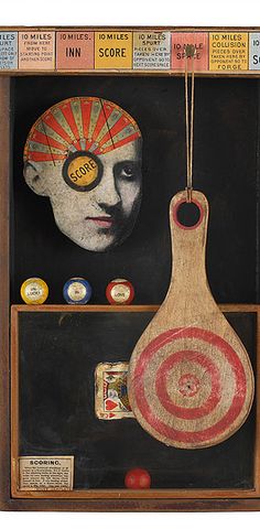 an art piece with a wooden spoon and target in the center, surrounded by other items