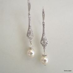 "These art deco style earrings have the perfect amount of sparkle to complement any gown. They have 10 mm Swarovski pearls in your choice of color. Earrings have vintage style filigrees with pave stones and cubic zirconia teardrops. They measure about 2 1/2\" long from top to bottom. Ear wire has tiny cubic zirconia stones set it for a perfect complement! They are perfect for your vintage inspired wedding or any special occasion! Most of my styles can be customized, just ask please =)" Elegant Pearl Crystal Earrings For Wedding, Elegant Chandelier Dangle Earrings For Wedding, Elegant Dangle Chandelier Earrings For Wedding, Wedding Silver Crystal Pearl Earrings, Elegant Pearl Embellished Chandelier Earrings For Wedding, Silver Pearl Chandelier Earrings For Wedding, Silver Pearl Crystal Earrings For Wedding, Wedding Pearl Chandelier Earrings In Silver, Classic Pearl Chandelier Earrings For Wedding