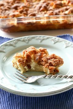 a piece of cake sitting on top of a white plate next to a fork and casserole dish