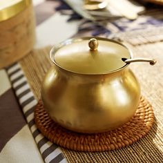 a gold pot sitting on top of a place mat