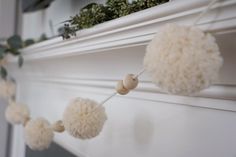 some white pom poms hanging from a mantle