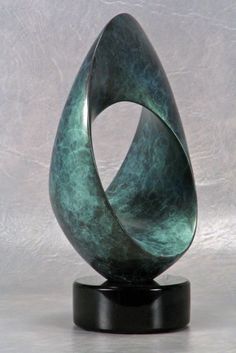 a green sculpture sitting on top of a black stand