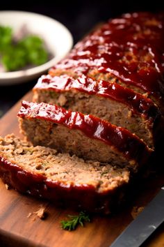 sliced meatloaf with ketchup on wooden cutting board