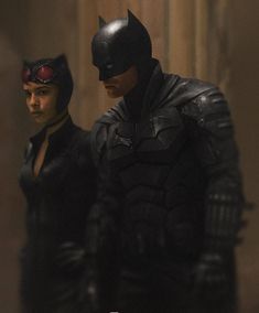 batman and catwoman standing next to each other