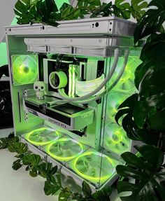 a computer case with green lights on the side and plants growing in front of it